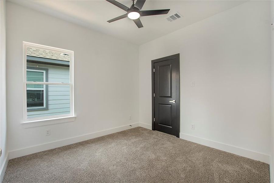 Carpeted empty room with ceiling fan