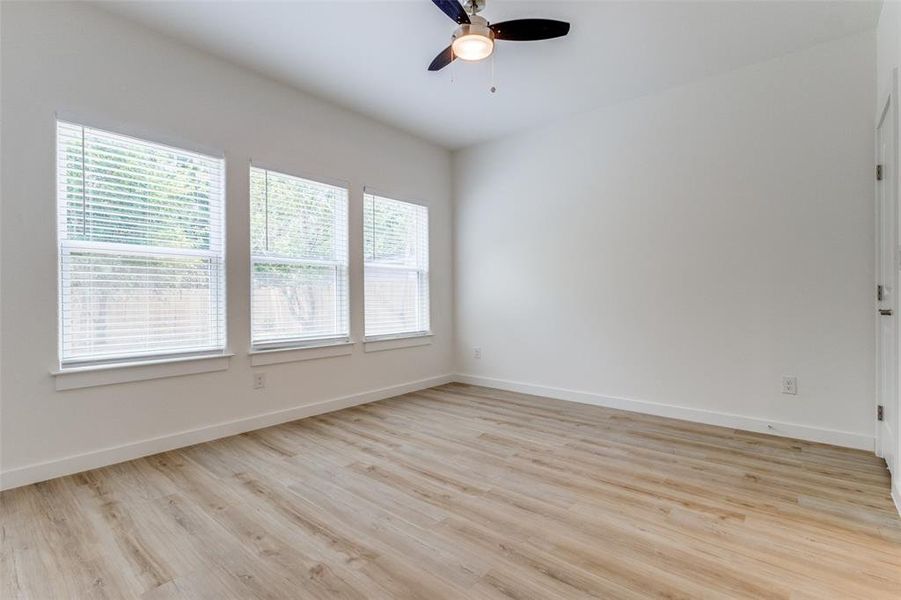 Unfurnished room with a healthy amount of sunlight, light wood-type flooring, and ceiling fan