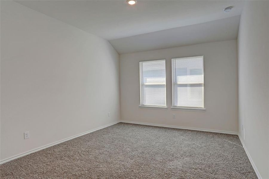 Carpeted empty room with lofted ceiling