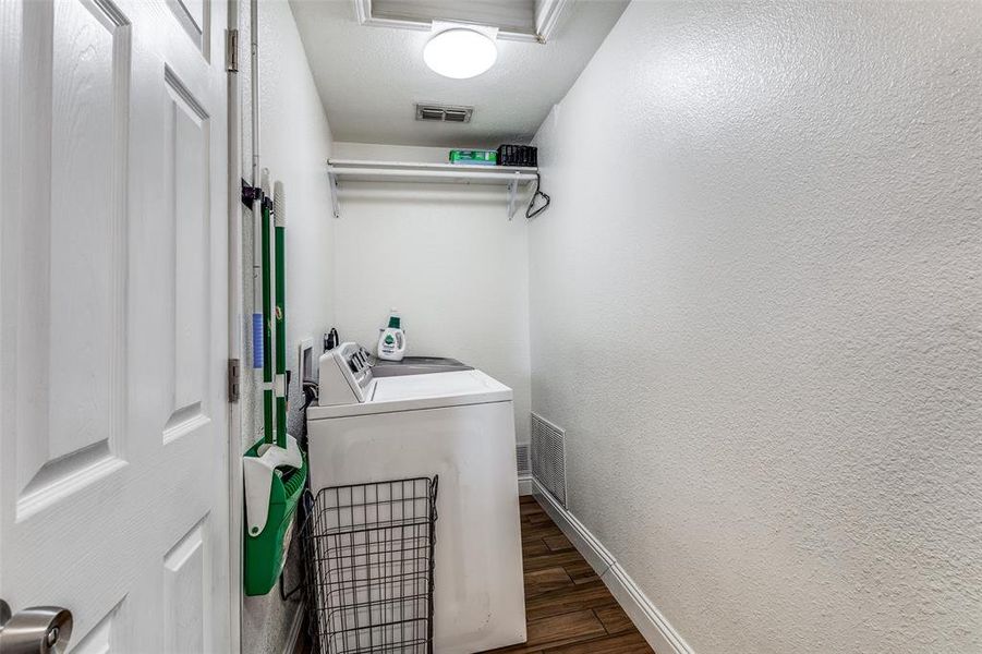 Laundry area featuring a textured ceiling, independent washer and dryer