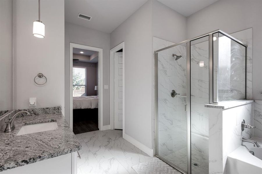 Bathroom featuring shower with separate bathtub and vanity