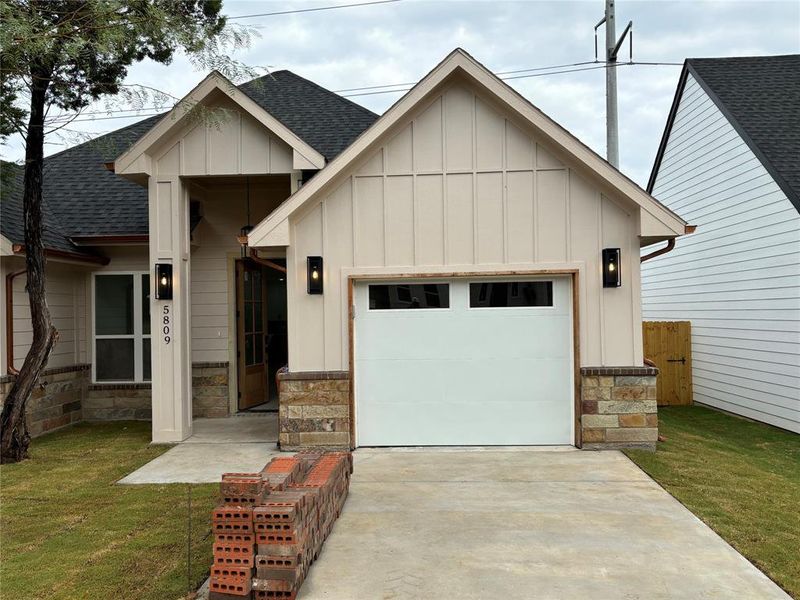 View of front of home featuring a front lawn and a garage