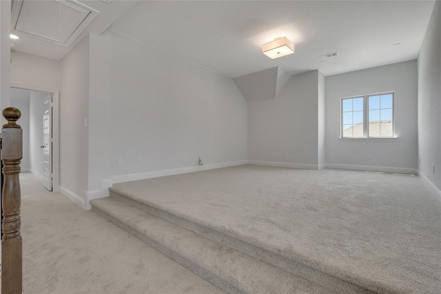 Additional living space featuring light carpet