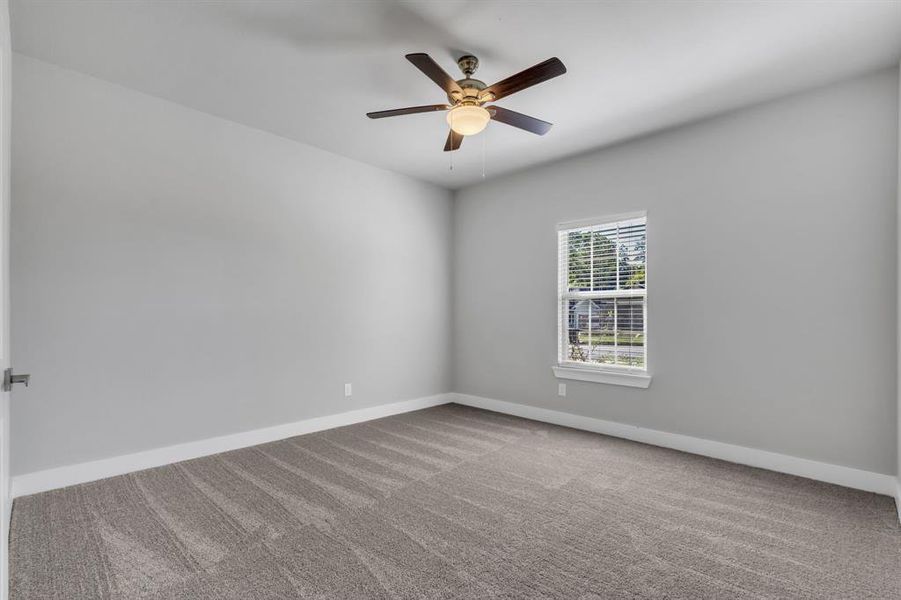 Empty room featuring carpet and ceiling fan