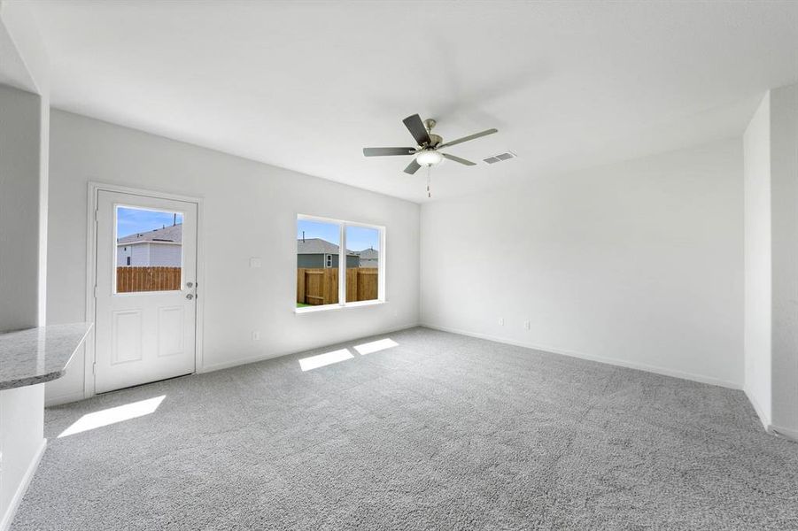 Carpeted living room featuring ceiling fan