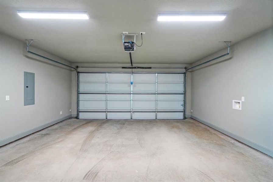 Garage with electric panel and a garage door opener