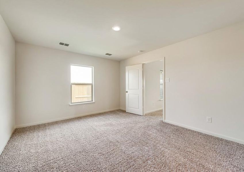 The master bedroom has brown carpet and light walls.