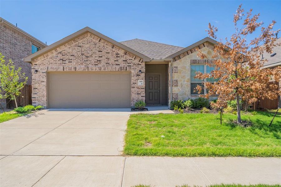 View of front of property with a front yard and a garage