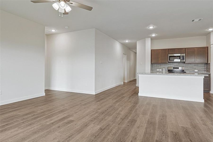 Unfurnished living room with ceiling fan and wood-type flooring