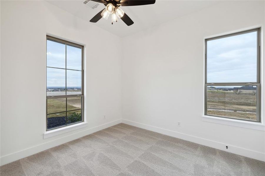 Unfurnished room featuring ceiling fan and light carpet