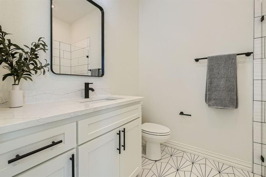 Bathroom with vanity, toilet, and tile patterned floors