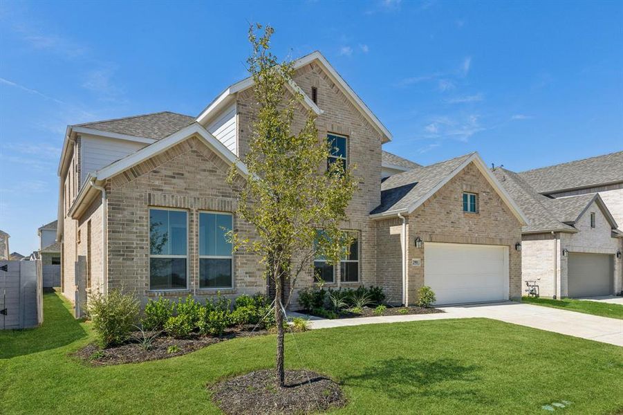 View of front facade featuring a front yard and a garage