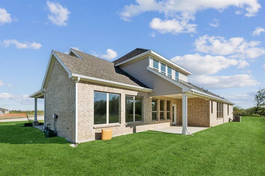 Back of house featuring a patio area, central AC, and a lawn