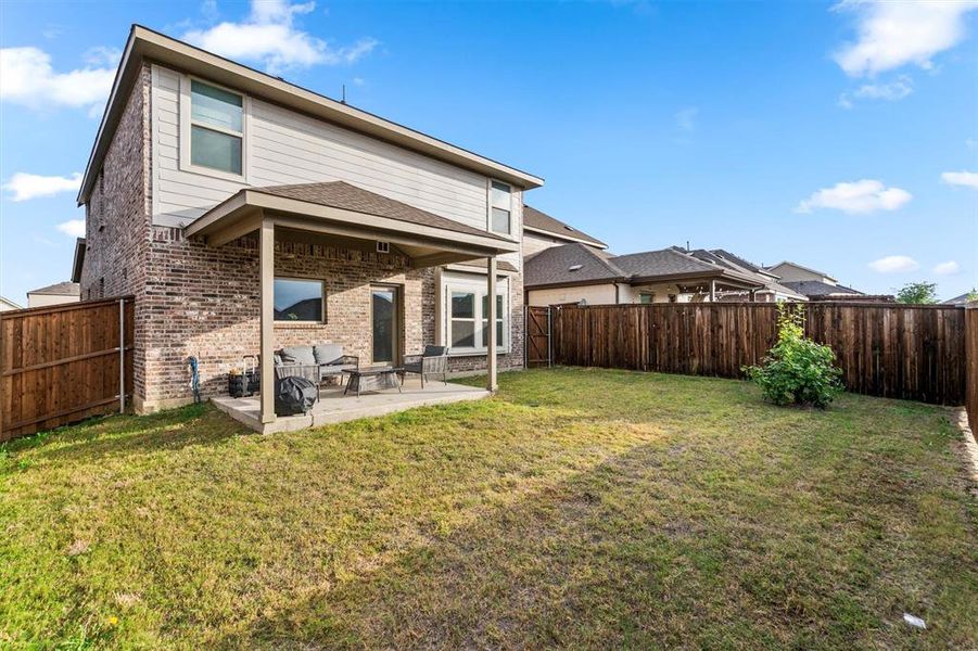 Rear view of property with a patio area and a yard