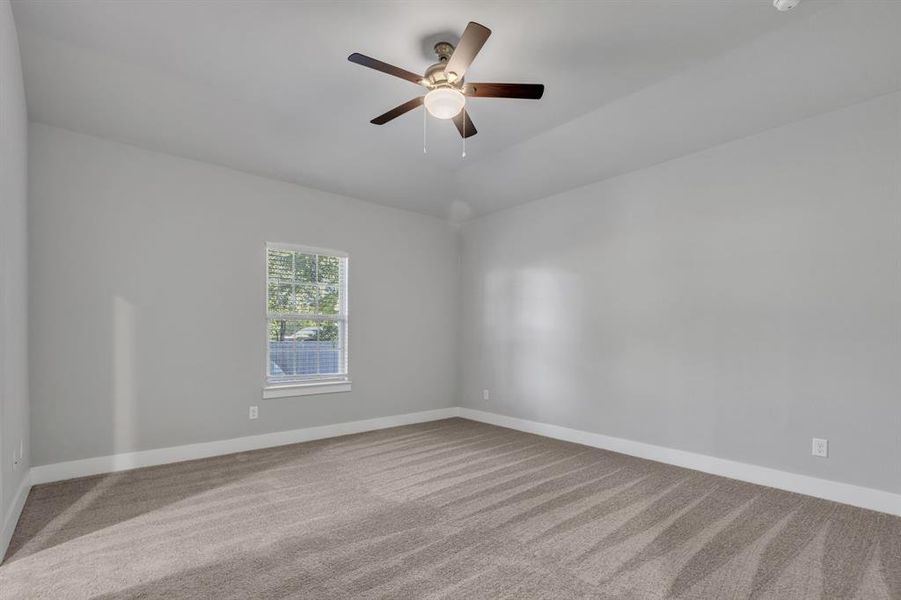 Empty room with ceiling fan and carpet floors