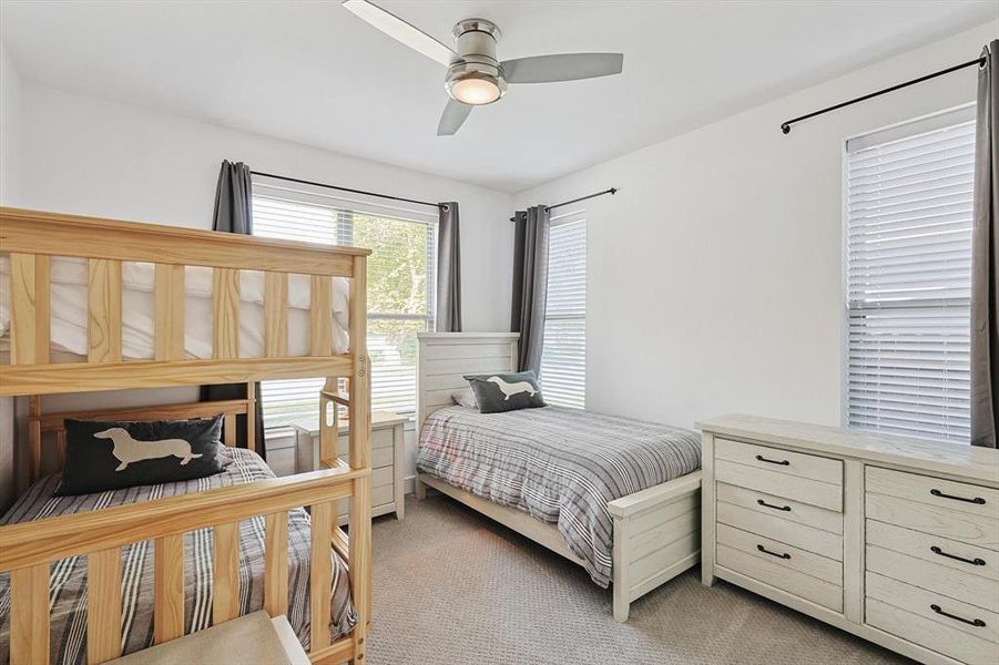 Carpeted bedroom featuring ceiling fan