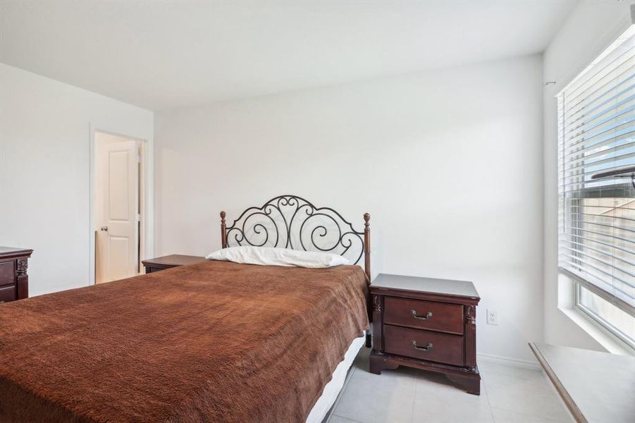 Tiled bedroom with multiple windows