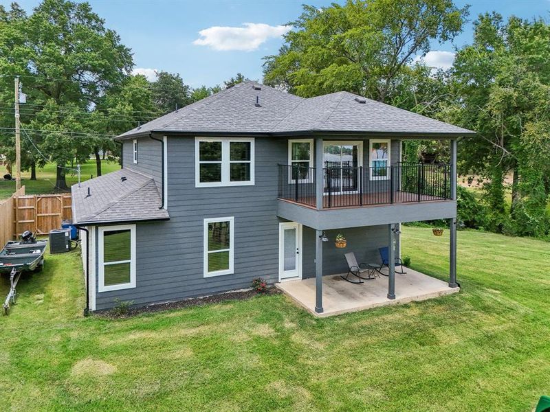 Back of house with central air condition unit, a yard, and a patio area