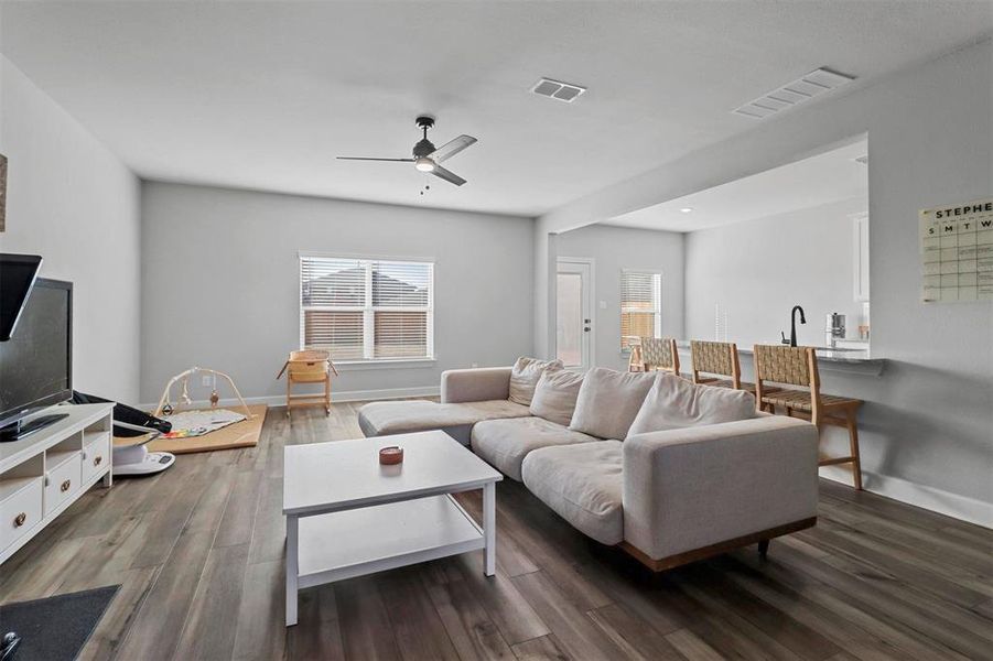 Living room with dark hardwood / wood-style floors and ceiling fan