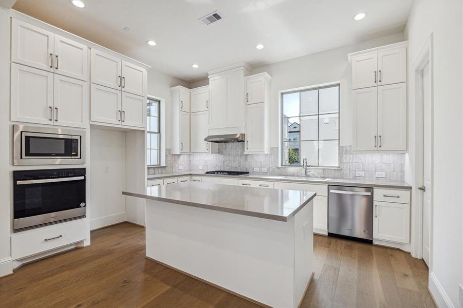 Tall ceilings and natural light with Large Kitchen area. Beautiful dual tone cabinets and easy to maintain quartz countertops