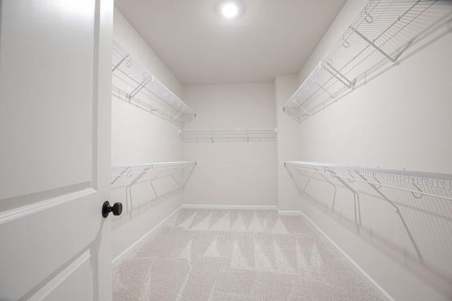 Owner's Spacious closet featuring carpet floors.  Photo not actual home, but previously built Mansfield plan.