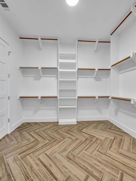 Walk in closet featuring light parquet flooring