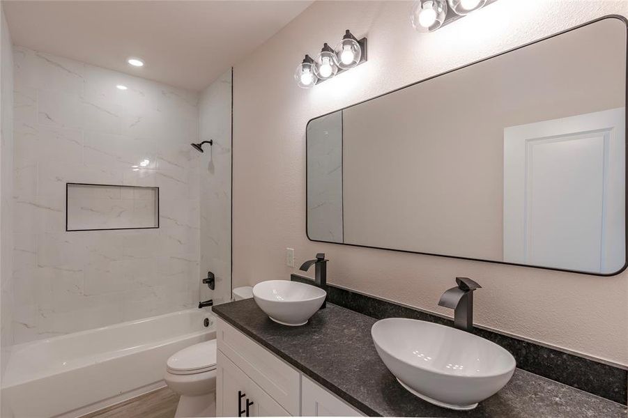 Full bathroom with tiled shower / bath, toilet, and vanity