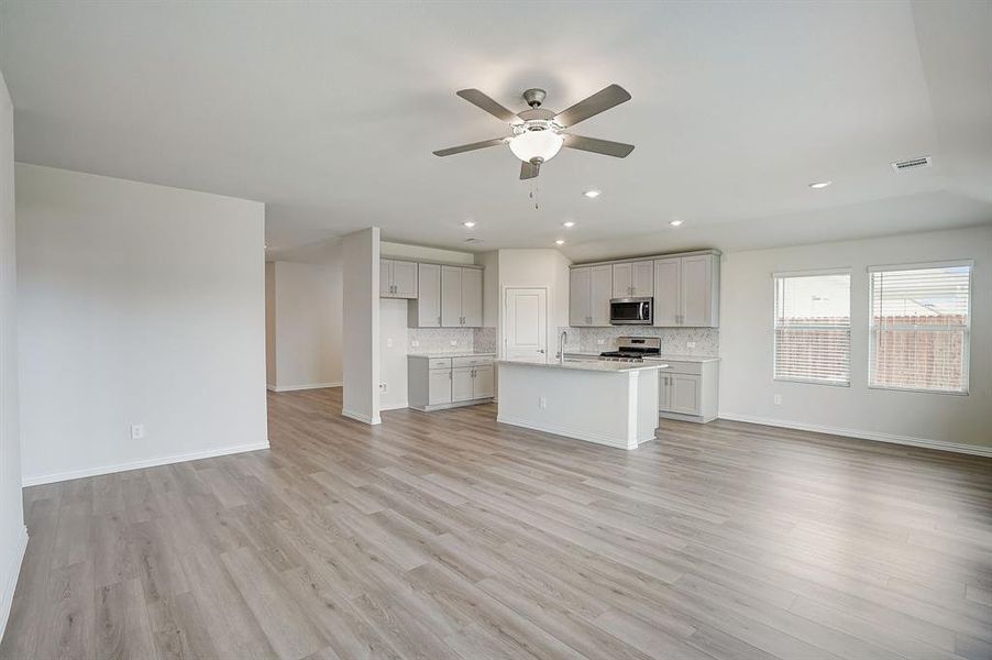 Living room/Dining area featuring light hardwood / wood-style floors, and ceiling fan