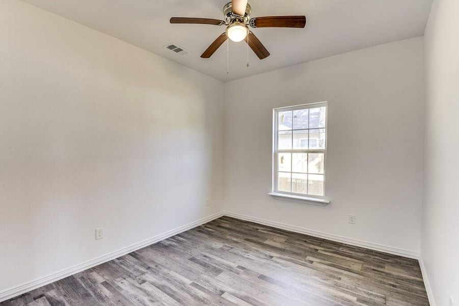 Empty room featuring hardwood / wood-style flooring and ceiling fan