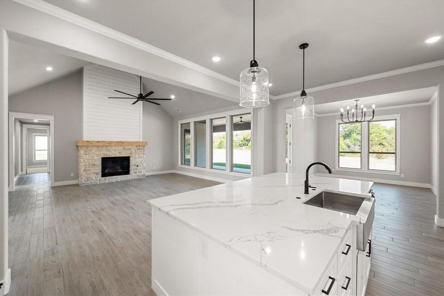 Kitchen with a healthy amount of sunlight, a fireplace, and vaulted ceiling