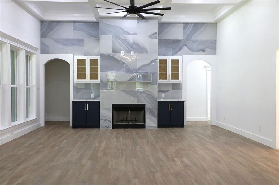 Wide open living room with wood look tile, fireplace and plenty of natural light.