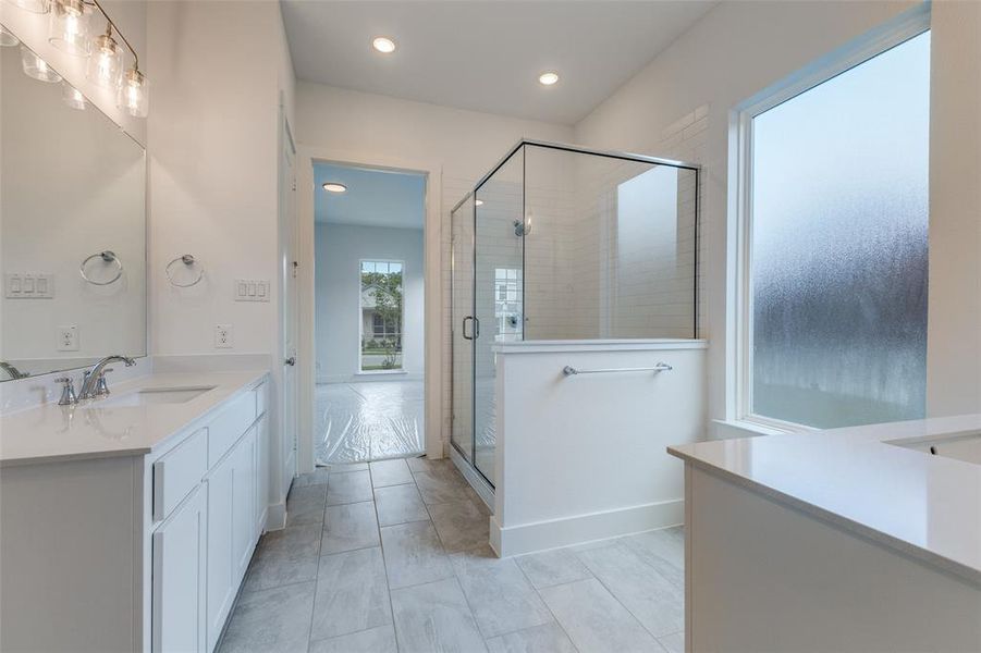 Bathroom with tile patterned floors, vanity, and an enclosed shower