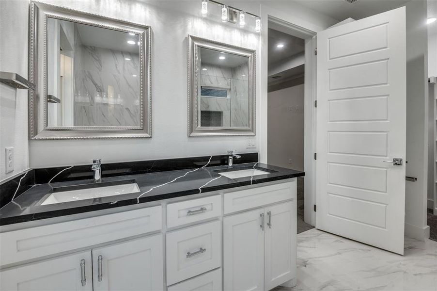 Master Bathroom with dual sinks and attached walk in closet along with a large stand up shower with a frameless glass door!