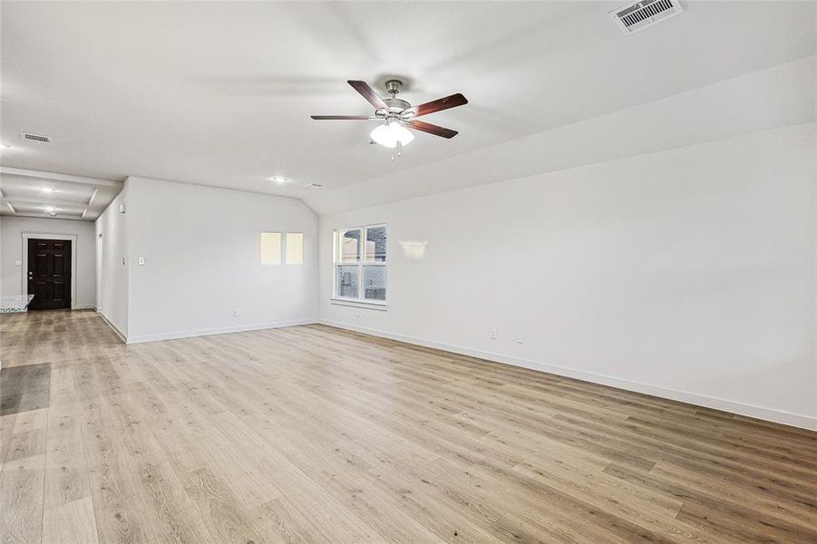 Unfurnished living room featuring ceiling fan and light wood-type flooring