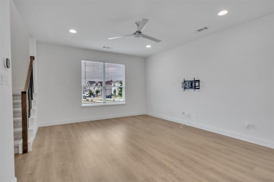 Living room featuring ceiling fan and light hardwood / wood-style flooring