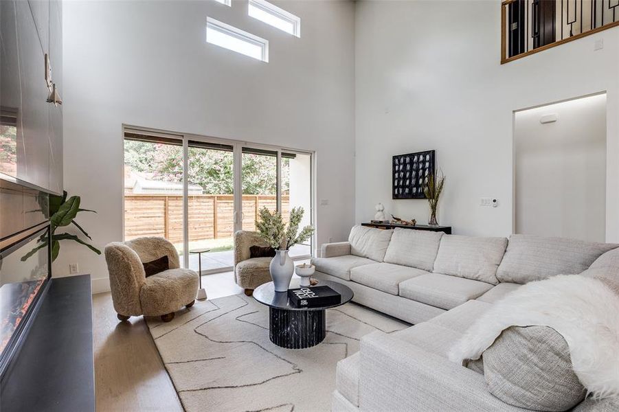 Living room with a high ceiling and hardwood / wood-style flooring