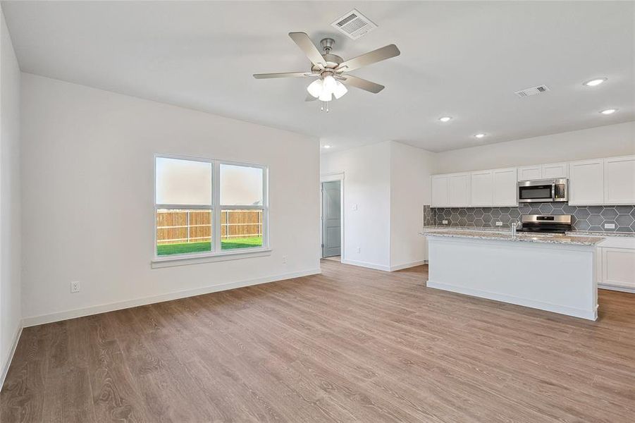 Kitchen featuring light wood-type flooring, white cabinetry, ceiling fan, and appliances with stainless steel finishes