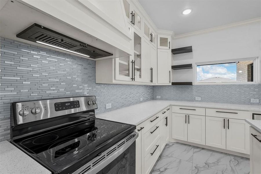 Kitchen featuring backsplash, custom range hood, electric range, and white cabinetry