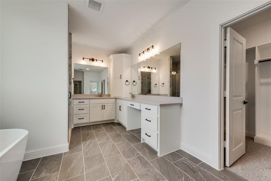 Bathroom featuring tile floors, vanity, and a washtub