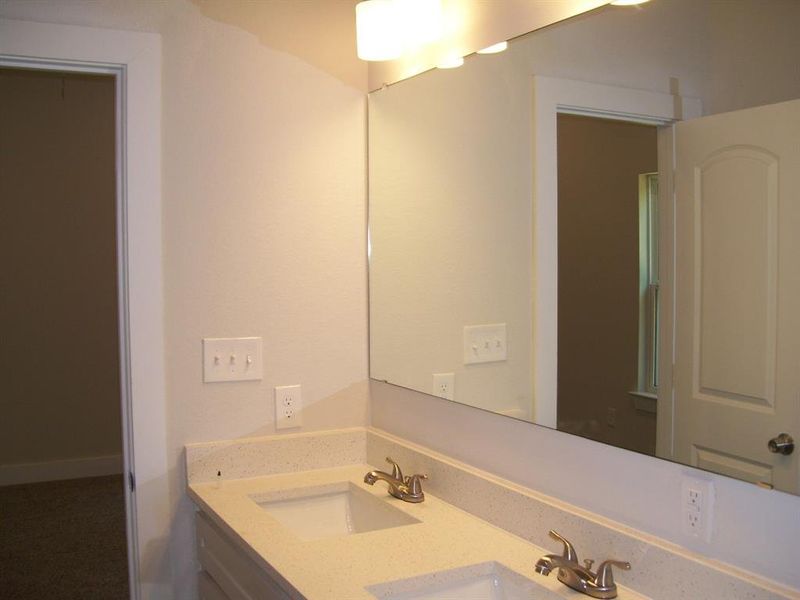 Primary bathroom with dual vanity and quartz countertop