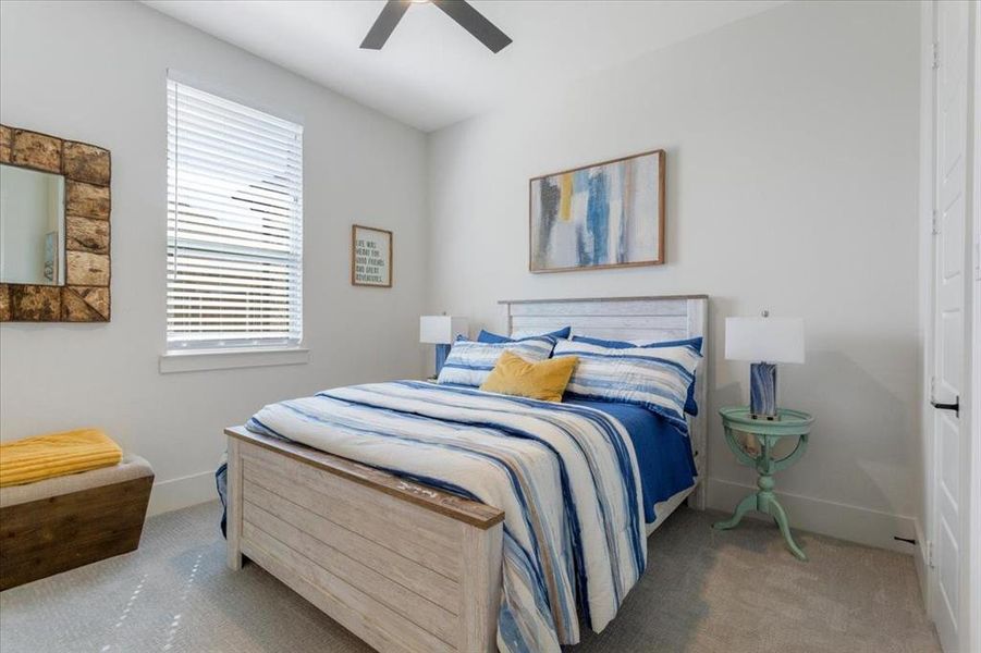 Carpeted bedroom featuring ceiling fan