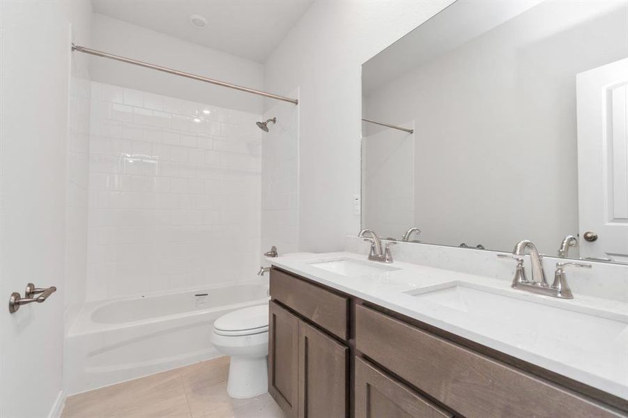 Enjoy the convenience of a double sink vanity in this stylishly designed bathroom. Sleek fixtures, ample counter space, and a pristine shower/tub combo offer both luxury and functionality. **This image is from another Saratoga Home - Clover floorplan.**