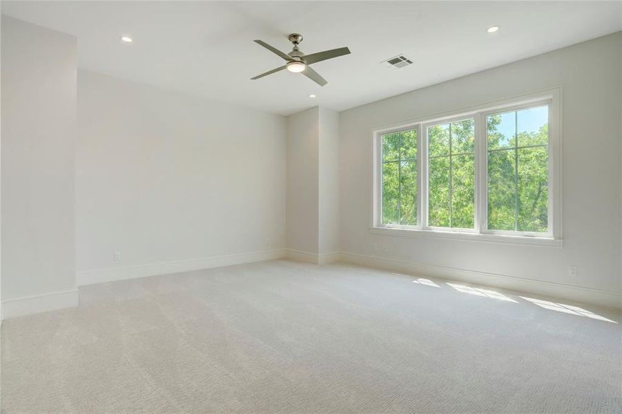 1 of 3 spacious upstairs Secondary Bedrooms with luxury carpet, modern ceiling fans, LED recessed lights, large windows and walk-in closets with built-in shelving and cabinets.