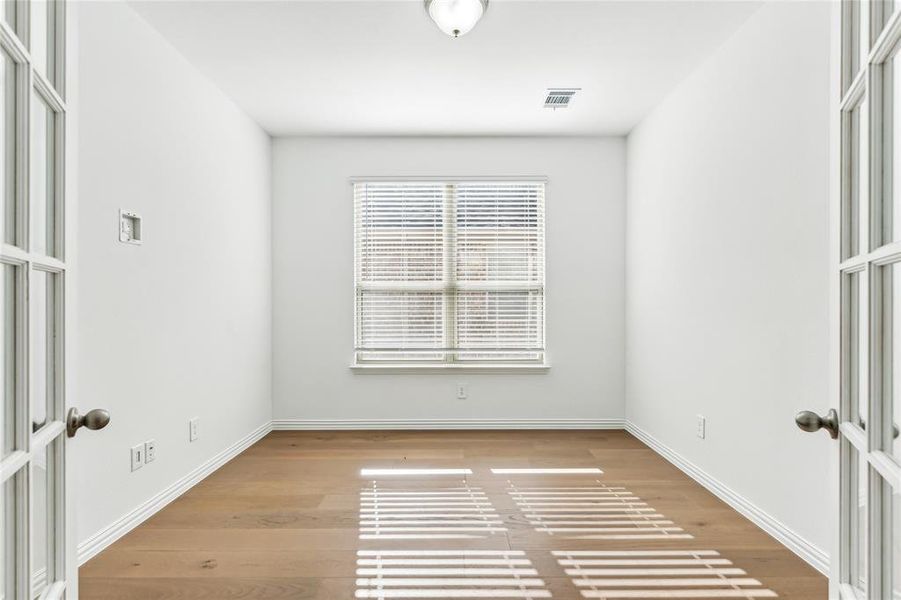 Empty room featuring hardwood / wood-style floors and french doors