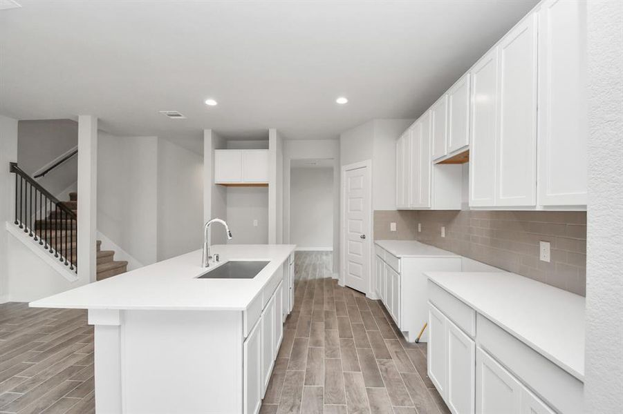 Discover another perspective of this stunning kitchen, generously appointed with an abundance of counter space. Sample photo, actual color and selections can vary.