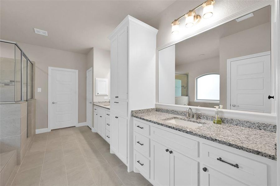 Custom cabinets, with built-in laundry basket storage, large walk-in closet with built-in organization