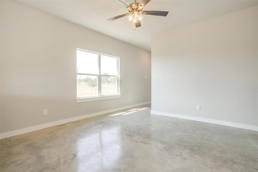 Unfurnished room featuring ceiling fan and concrete floors