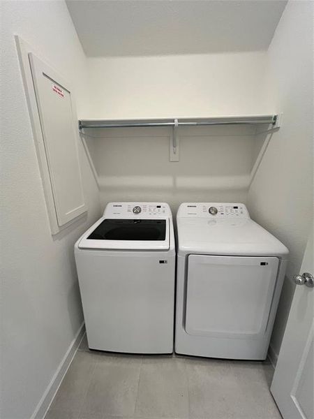 Clothes washing area featuring light tile flooring and independent washer and dryer