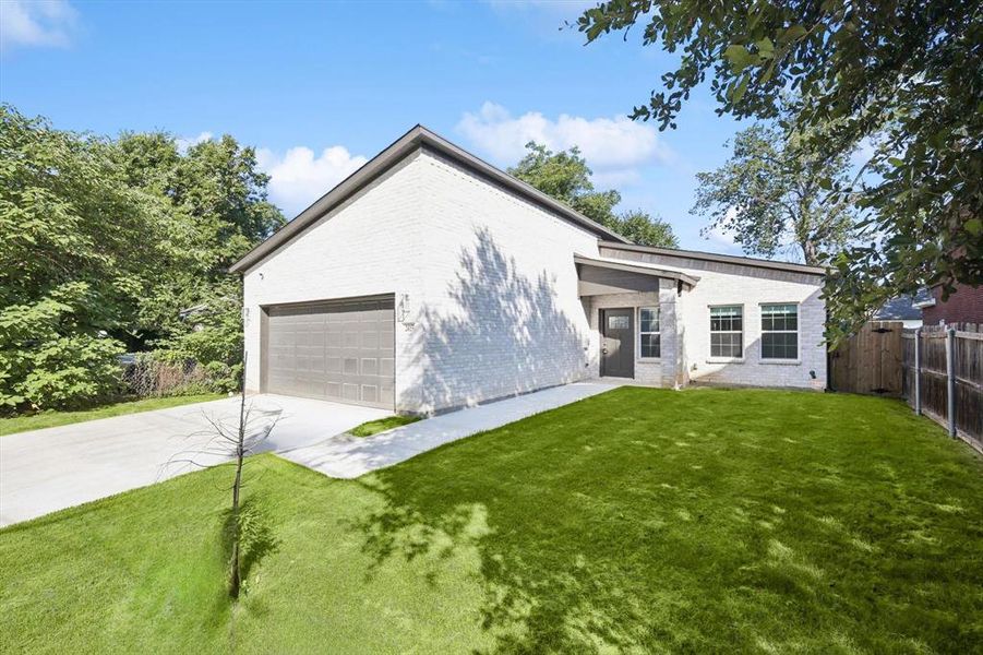 View of front of home featuring a garage and a front lawn