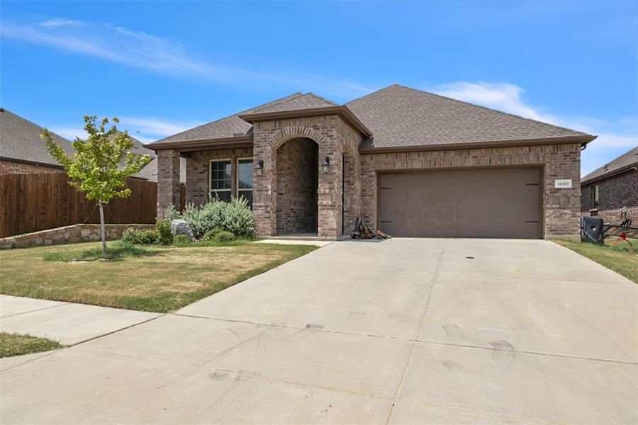 View of front facade with a garage and a front lawn